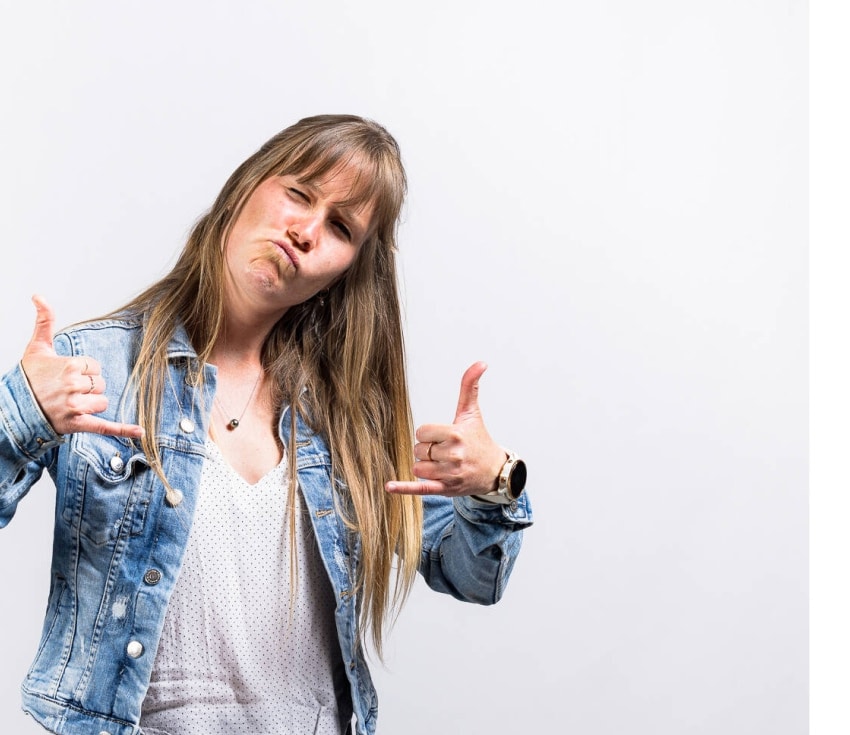 Woman making a funny face and shaka hand signs in denim jacket
