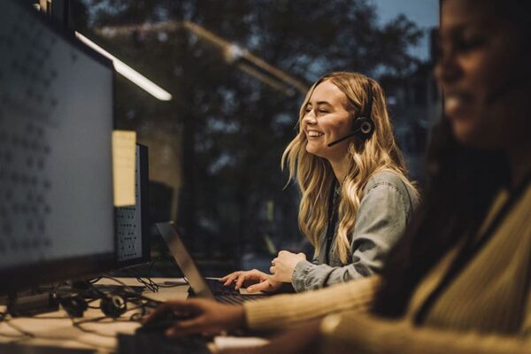 Femme portant un casque en pleine discussion devant un ordinateur