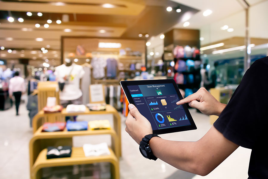 Personne tenant une tablette dans un magazin